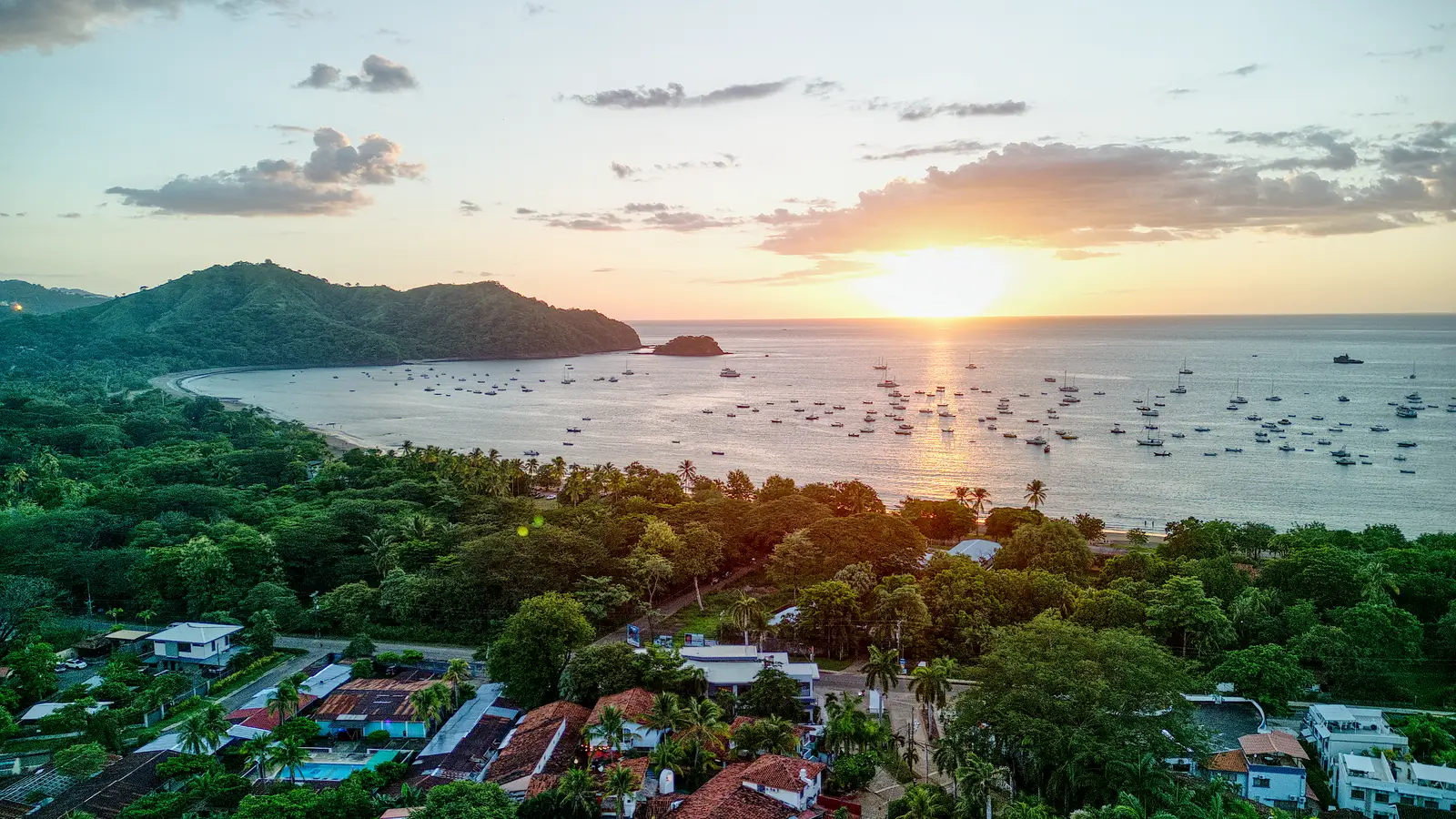 Playas del Coco from the air at sunset, with boats moored in the bay